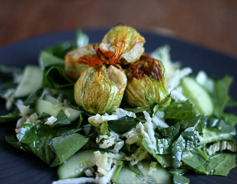 Stuffed and roasted zucchini flowers filled with a creamy vegan cashew cheese filling