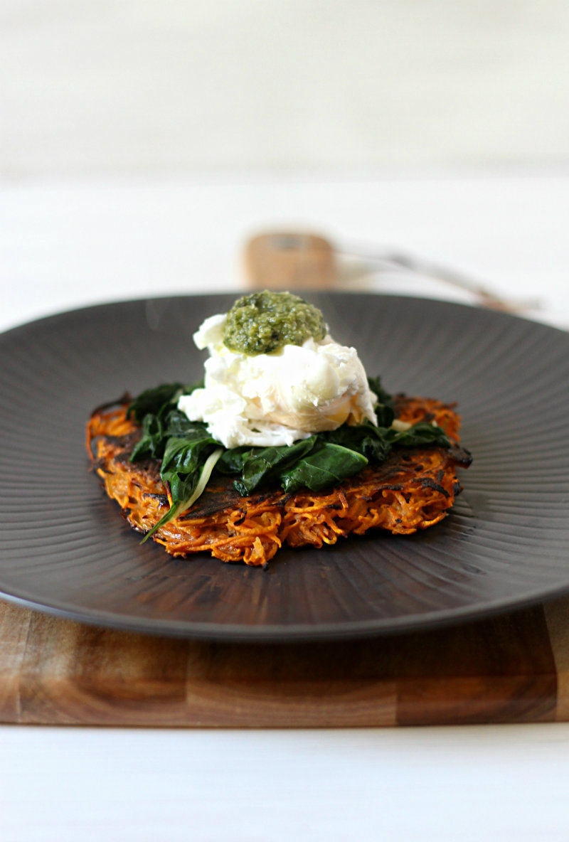 Delicious sweet potato fritters topped with garlicky greens, a poached egg and pesto
